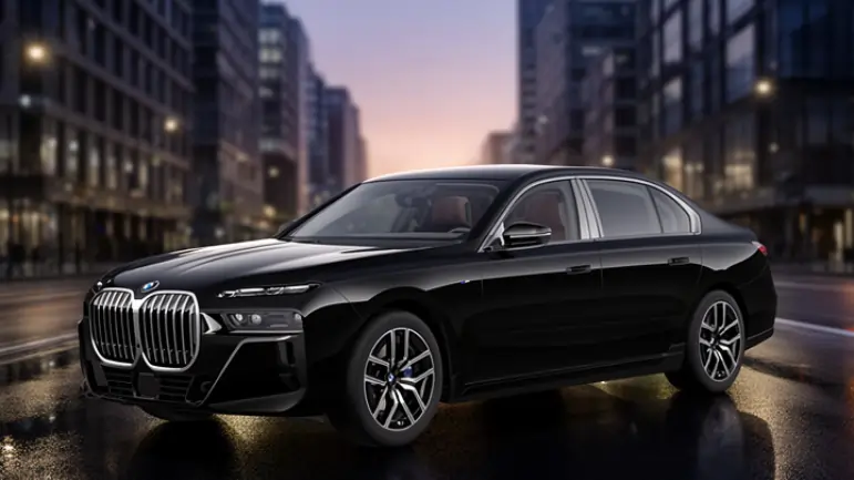 BMW 7 Series black luxury sedan parked on a modern city street with illuminated buildings and wet road reflection